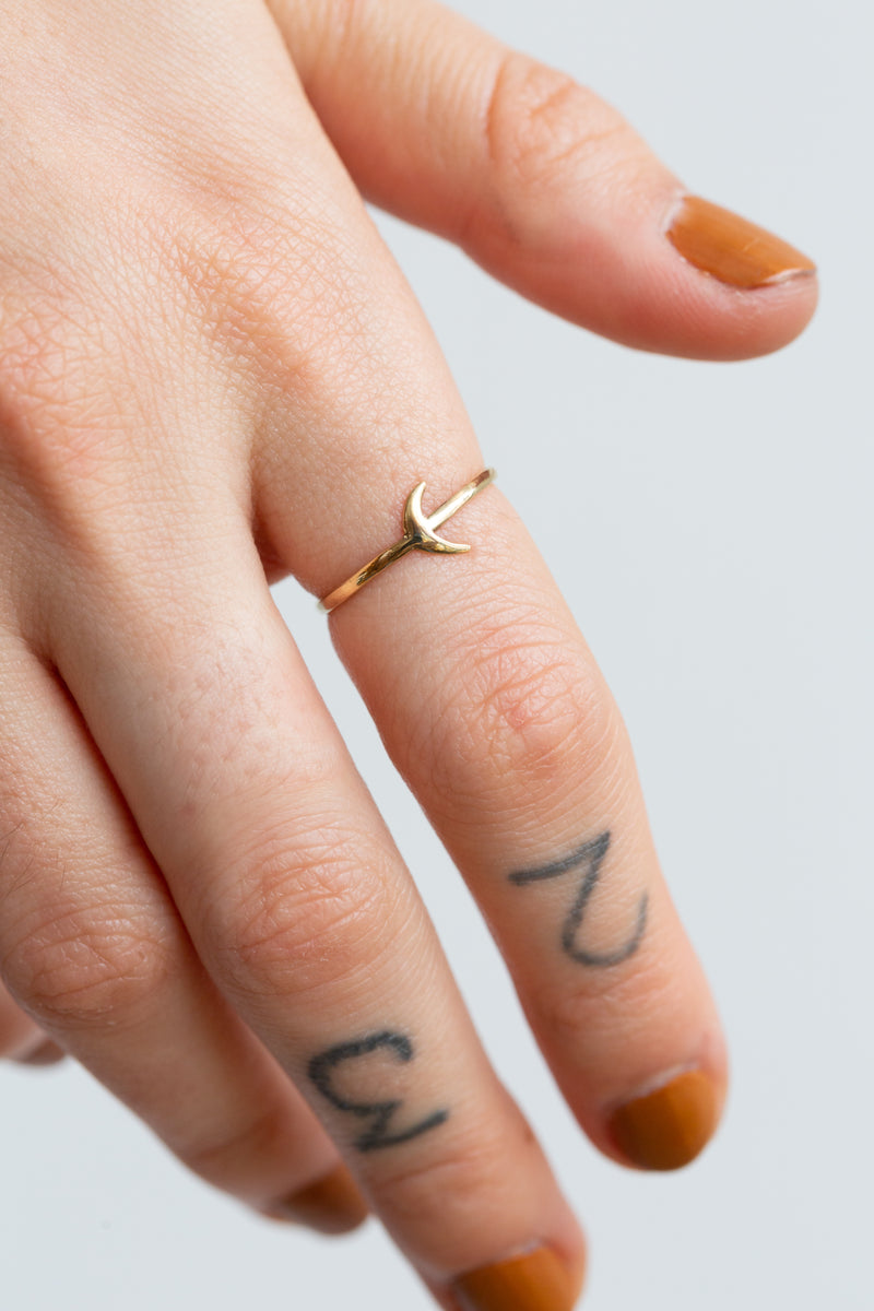 Person wearing Moon+Arrow's fine jewelry crescent moon ring in 10kt yellow gold