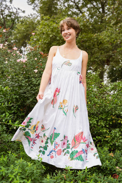 Woman wearing a beautiful white and floral Injiri Rasa Dress