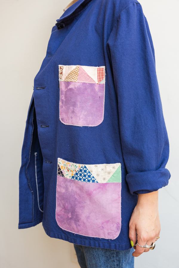 Person wearing a blue Half Skein chore jacket with purple patches