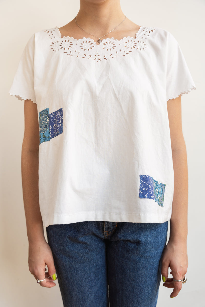Person wearing a Half Skein white top with patches