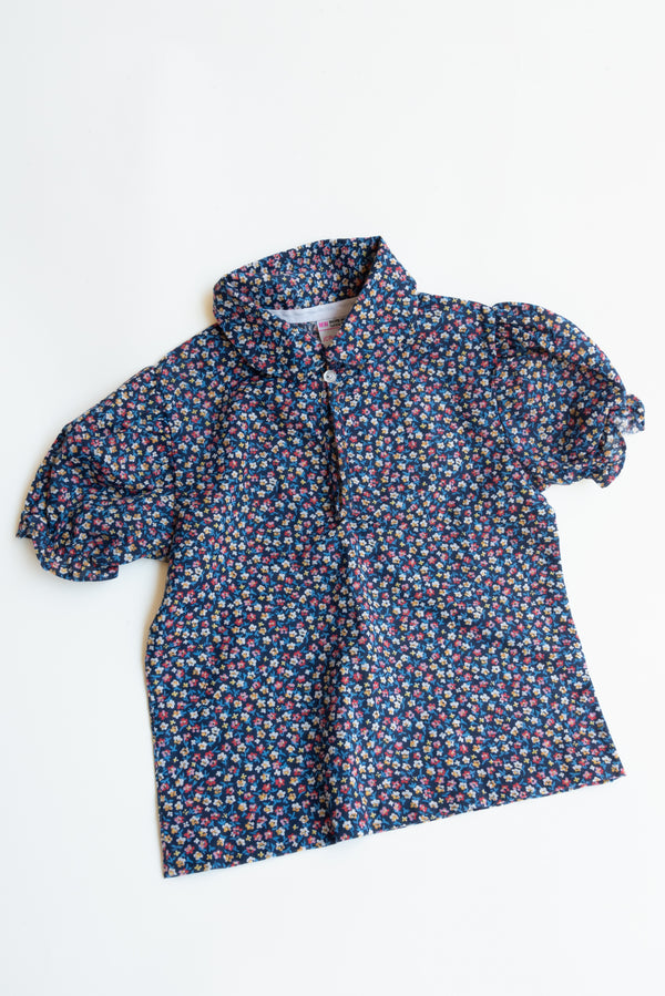 Short sleeve floral blouse from Gus & Way, marked size 4T on the tag, featuring a vibrant floral pattern. Ideal for warm weather and playful children’s fashion.