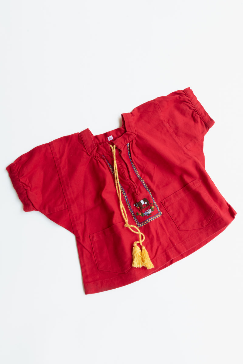 Guatemalan Red Embroidered Blouse from Gus & Way, featuring intricate embroidery and a vibrant red color. Perfect for adding cultural charm to children’s vintage fashion.