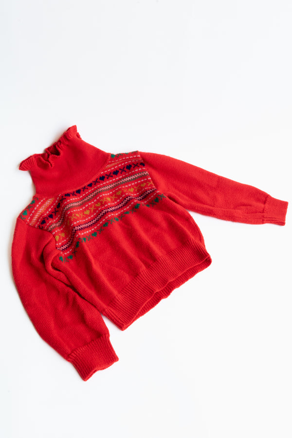 Red turtleneck frilly sweater from Gus & Way, featuring a heart and X design stitched on the chest. Ideal for adding vintage charm and style to children’s fashion.