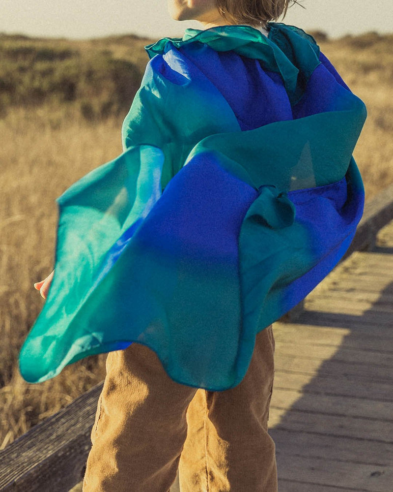 Child wearing Sarah's Silks Silk Capes in blue and green