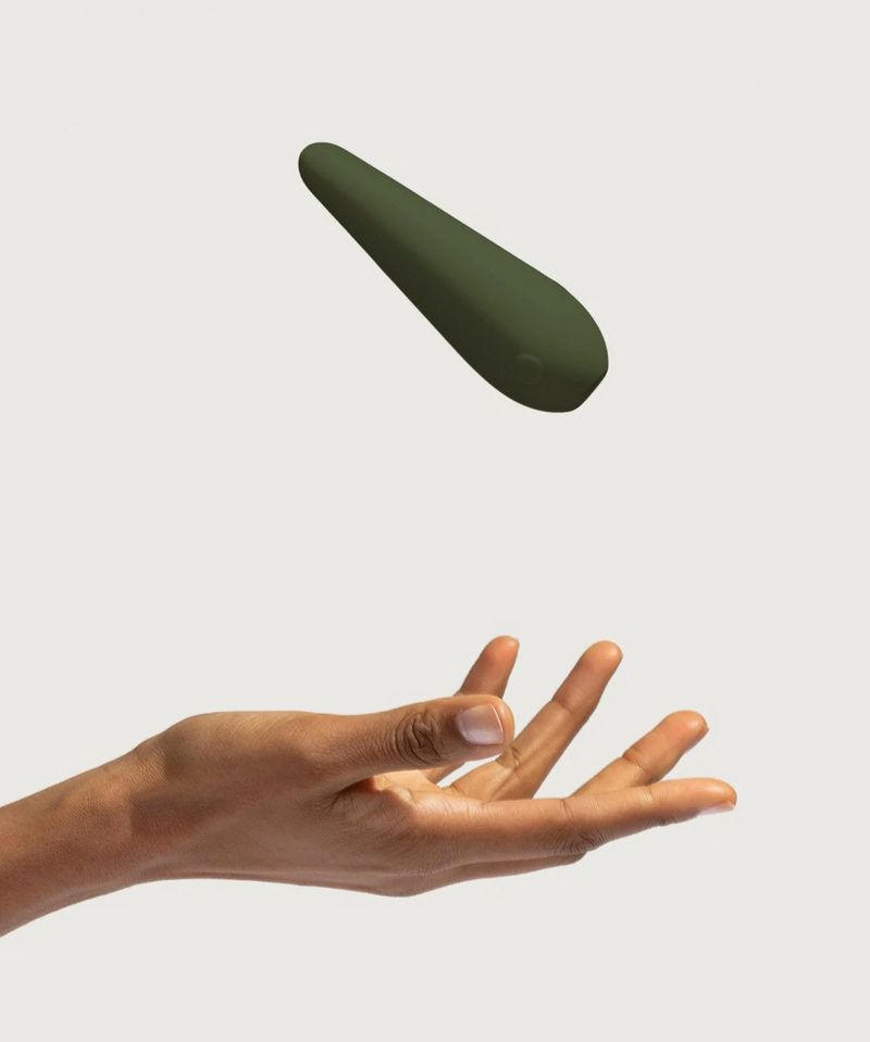 A person tossing a Maude Vibe Personal Massager into the air