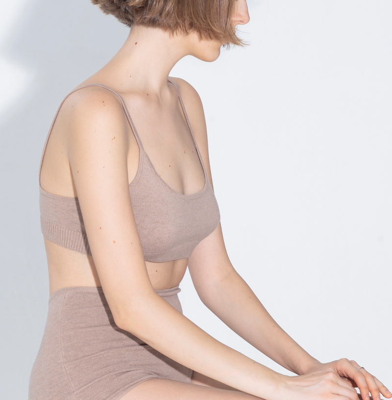 A model wears a natural-colored cotton silk sporty bralette with bottom ribbing