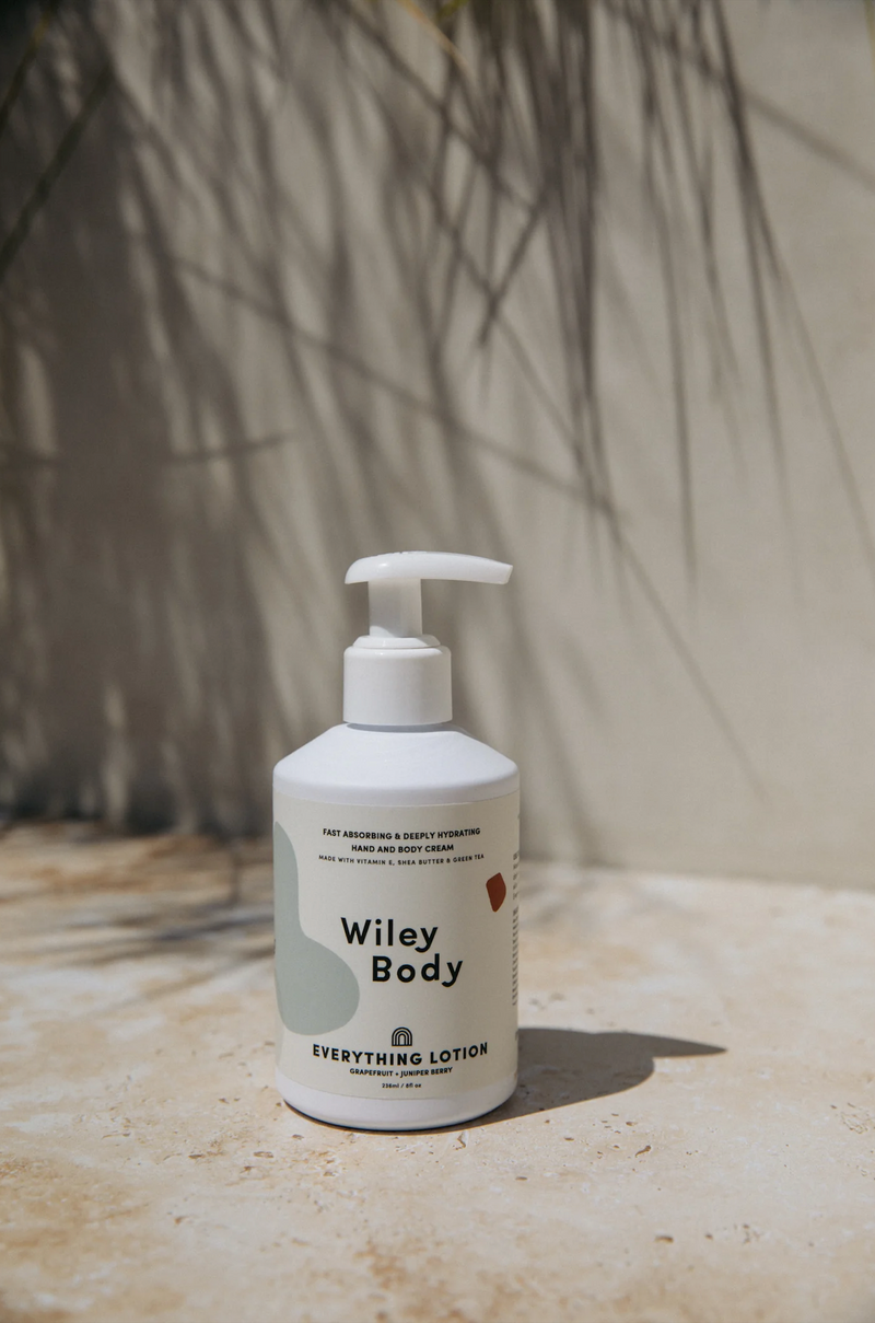 A bottle of Wiley Body Everything Lotion, a lightweight, creamy, and cloudlike lotion, sitting on a tabletop