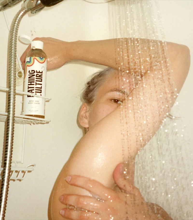 A person using a bottle of Bathing Culture Mind and Body Wash, organic, biodegradable, all-purpose soap