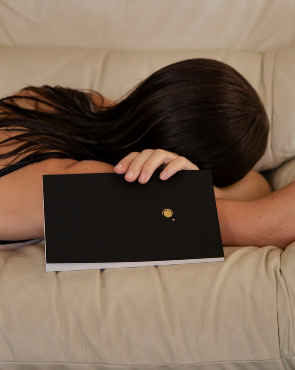 Person holding a Wilde House Night Journal, a lightly guided journal intended to support your evening ritual and foster a state of reflection at the close of your day