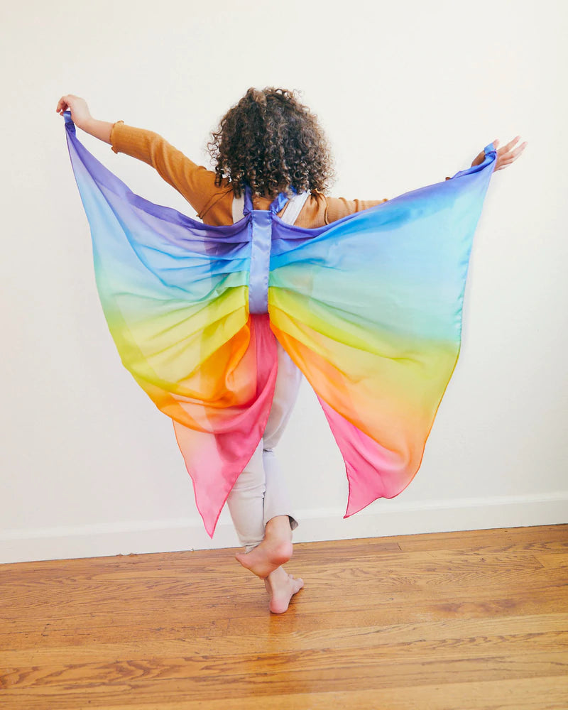 Child wearing Sarah's Silks Wings in rainbow colors