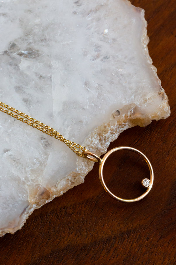 Halcyon Helios necklace, made out of 14k yellow gold with a cruelty free diamond beautifully placed on the center of the circle pendant
