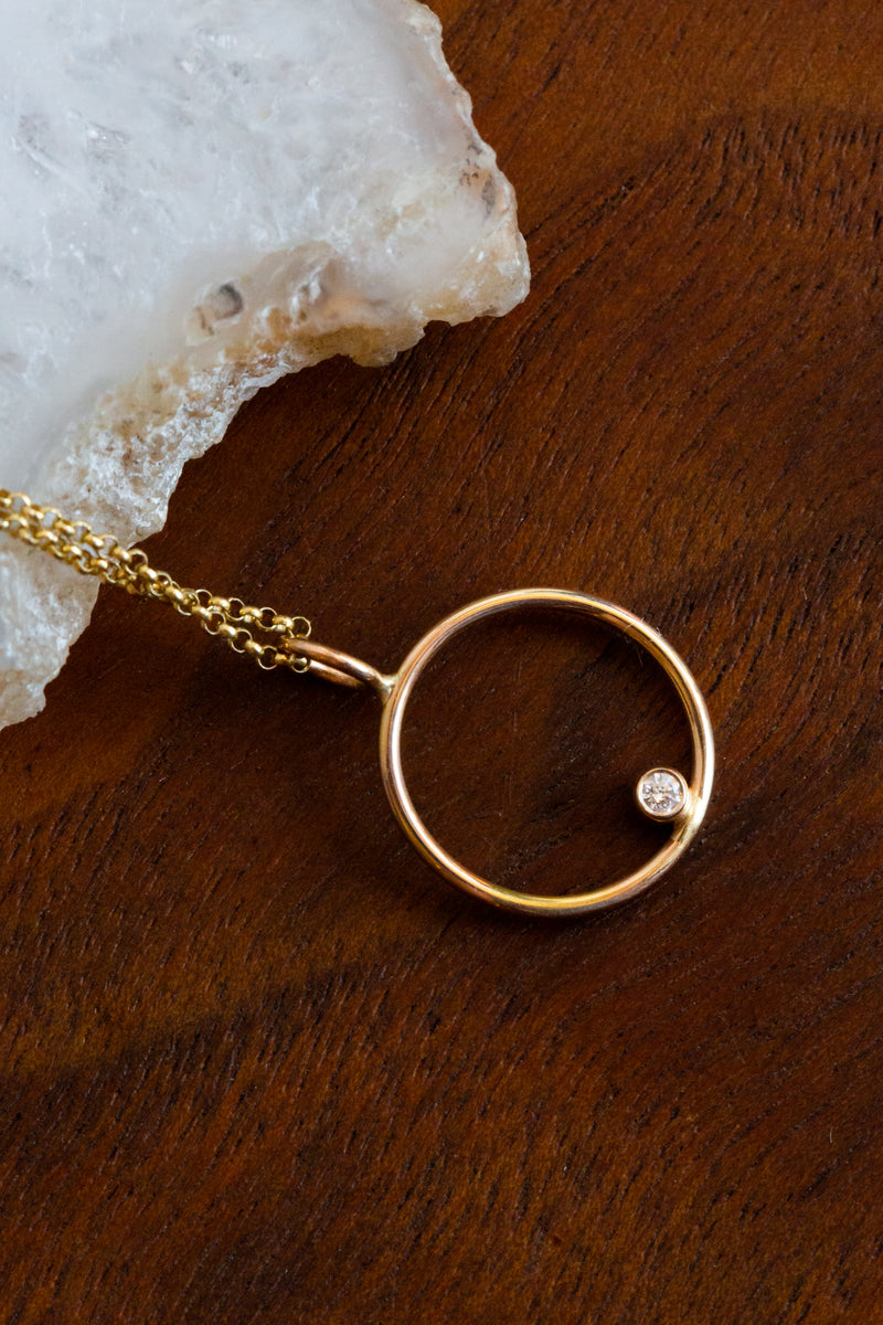 Halcyon Helios necklace, made out of 14k yellow gold with a cruelty free diamond beautifully placed on the center of the circle pendant