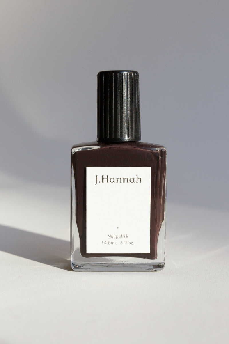 A bottle of dark brown nail polish by J.Hannah