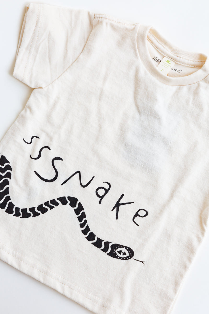 A baby Joan Ramone snake t-shirt made of 100% organic cotton with a slithering snake hand-printed on front and back, laying flat on a table