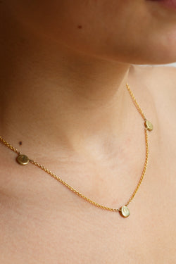 Person wearing Moon+Arrow's triple full moon necklace