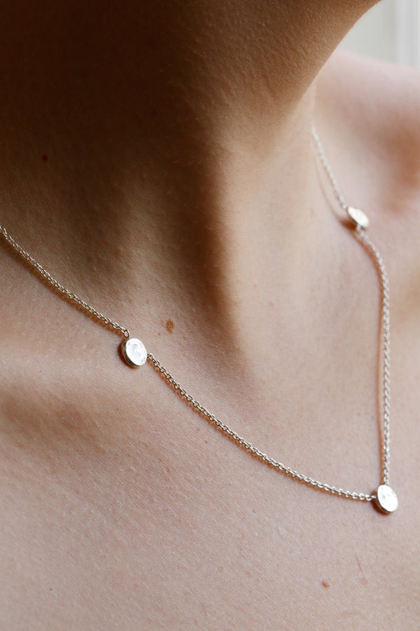 Person wearing Moon+Arrow's triple new moon necklace