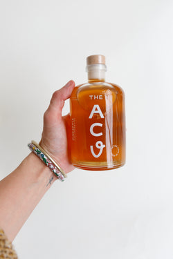 Person holding a bottle of Pineapple Collaborative Apple Cider Vinegar
