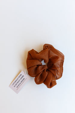 One dark orange colored Rosemarine scrunchies made with silk organza and dyed using plant matter and organic materials in Detroit