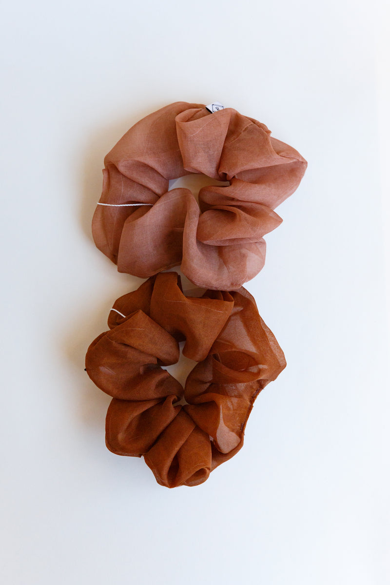 Two dark orange/red colored Rosemarine scrunchies made with silk organza and dyed using plant matter and organic materials in Detroit