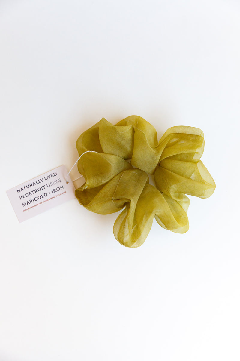 One yellow/green colored Rosemarine scrunchies made with silk organza and dyed using plant matter and organic materials in Detroit