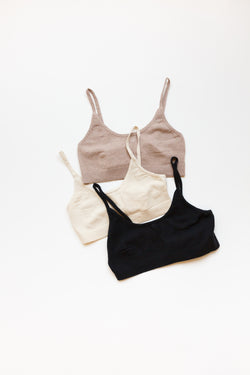 A collection of cotton silk sporty bralettes with bottom ribbing on display on a table