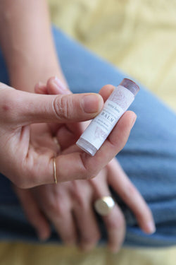 Person holding Terra Luna Tinted Lip Balm made from Beet Root coloring and Alkanet root powder with herb-infused oils and beeswax