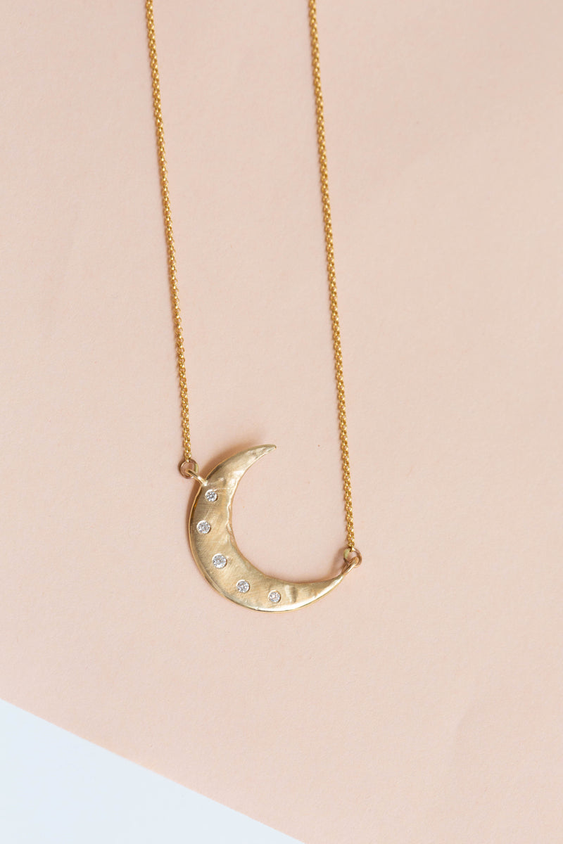 A beautiful handcrafted 14k gold crescent moon necklace handmade in New Mexico by artist Halcyon