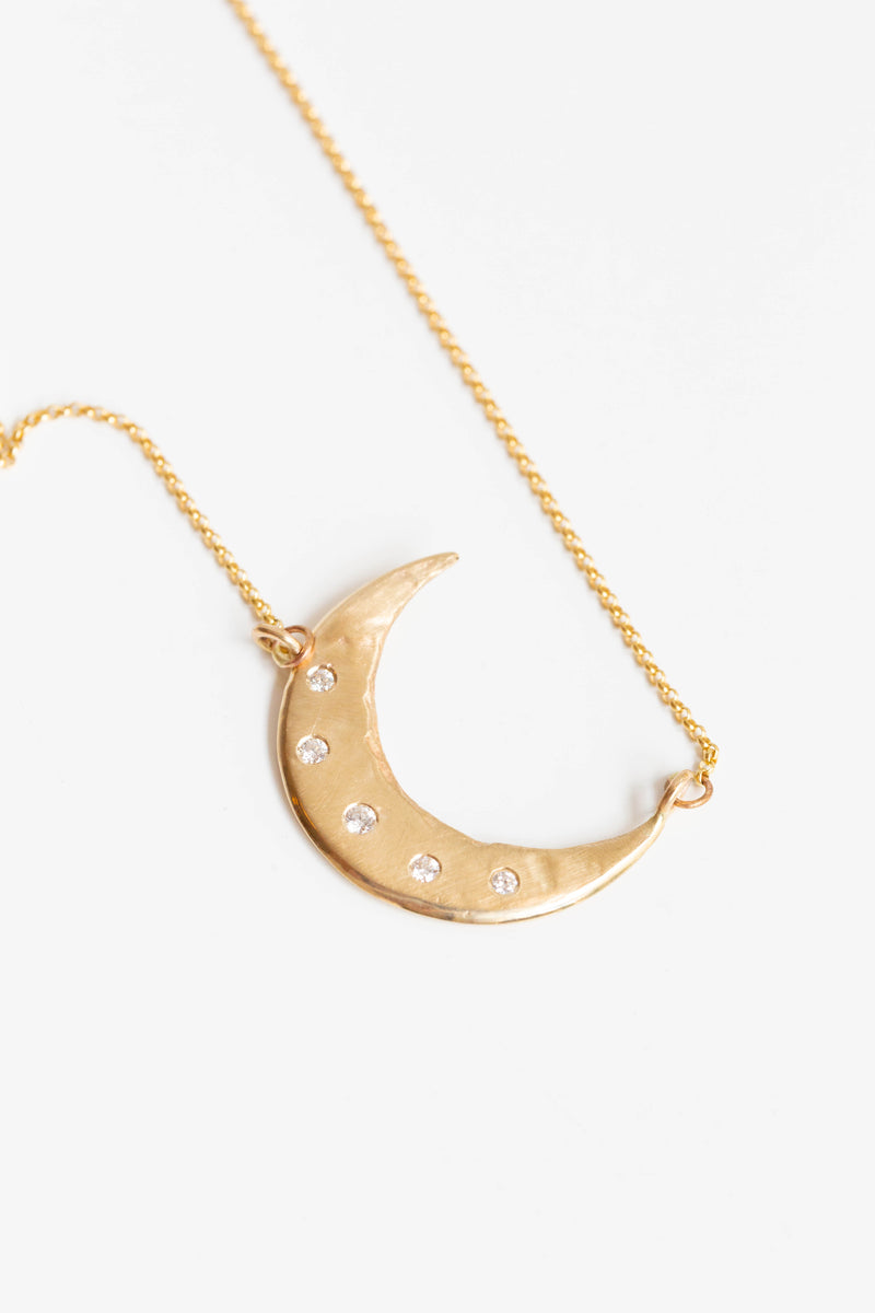 A beautiful handcrafted 14k gold crescent moon necklace handmade in New Mexico by artist Halcyon