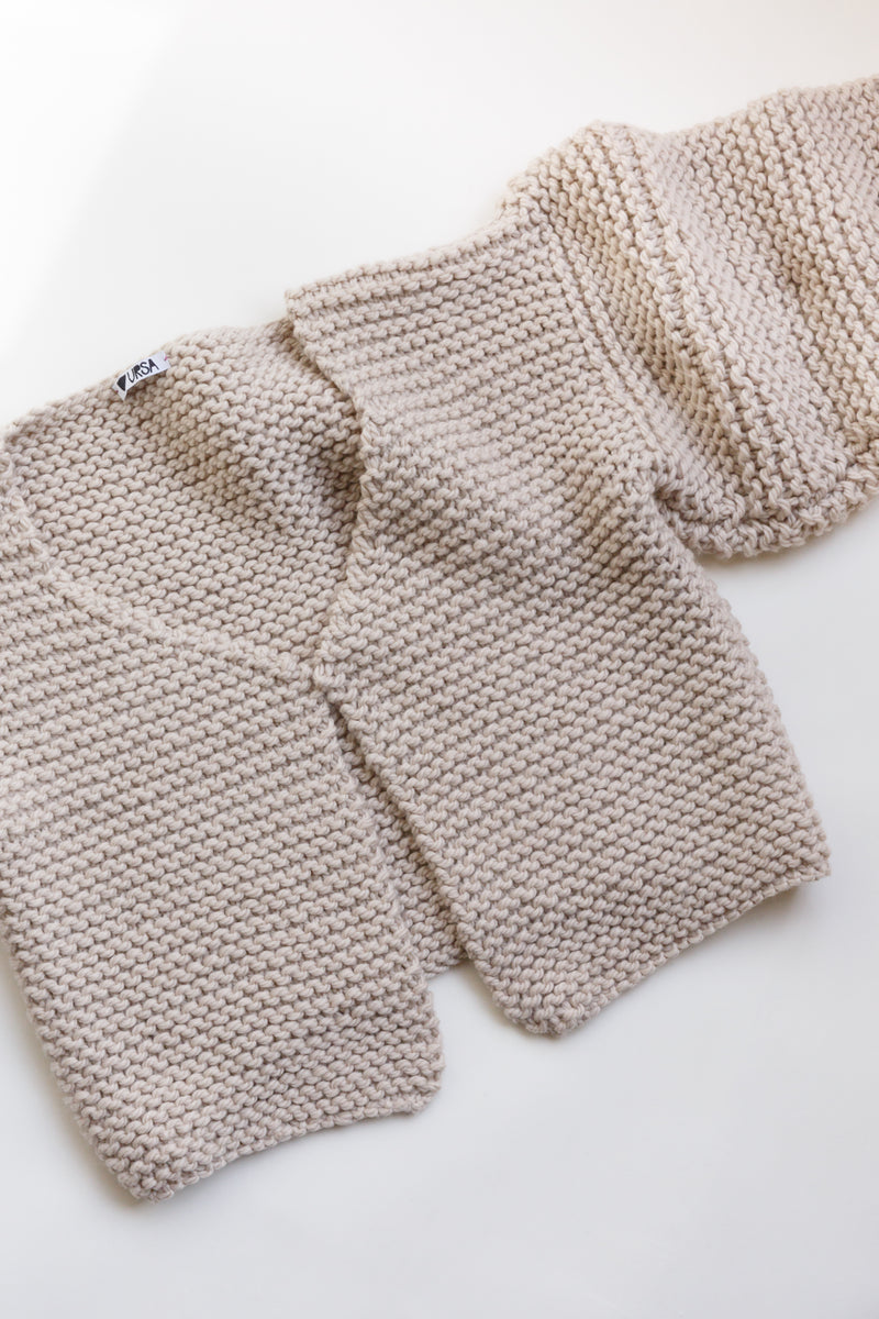 Handcrafted by women artisans in South America and made from the highest quality natural fibers sourced in Patagonia and The Andes, this chunky merino wool cardigan sweater is slightly cropped and is on display on a flat table