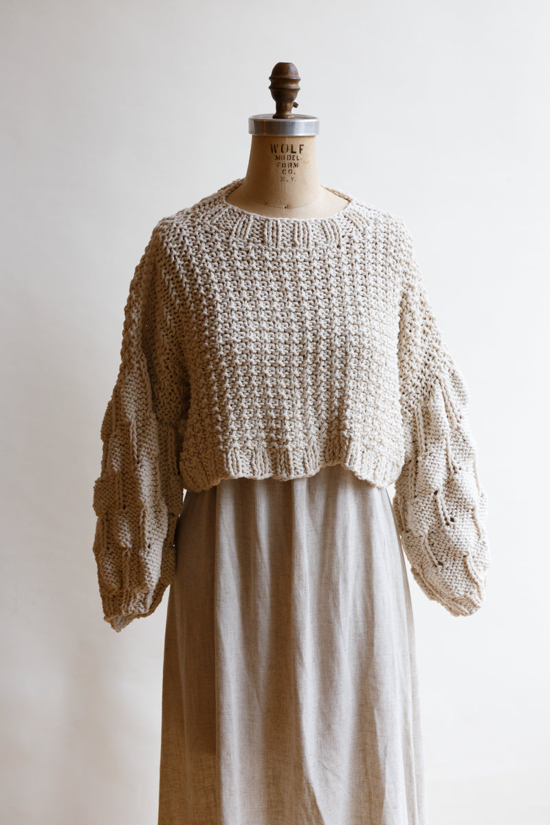 Handcrafted by women artisans in Argentina, this oversized chunky cotton pullover sweater is on display on a mannequin and features balloon sleeves from Ursa Textiles