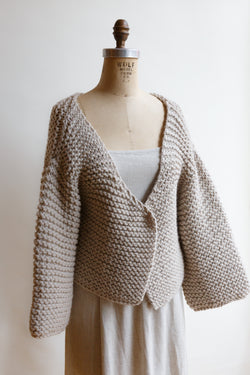 Handcrafted by women artisans in South America and made from the highest quality natural fibers sourced in Patagonia and The Andes, this chunky merino wool cardigan sweater is slightly cropped and is on display on a mannequin