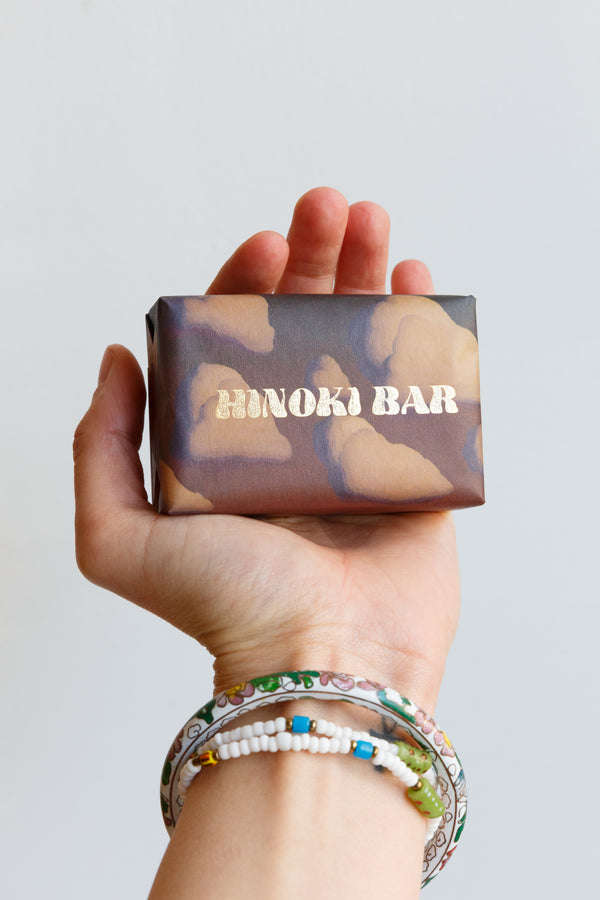 A person holding a bar of Wonder Valley Hinoki Oil Bar Soap